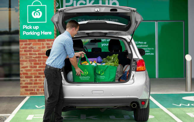 Woolworths Team member placing groceries in a car boot